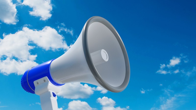 An image of a white megaphone with blue accents, against a blue, cloudy sky.