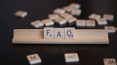 A scrabble set which have letters that read "F.A.Q."