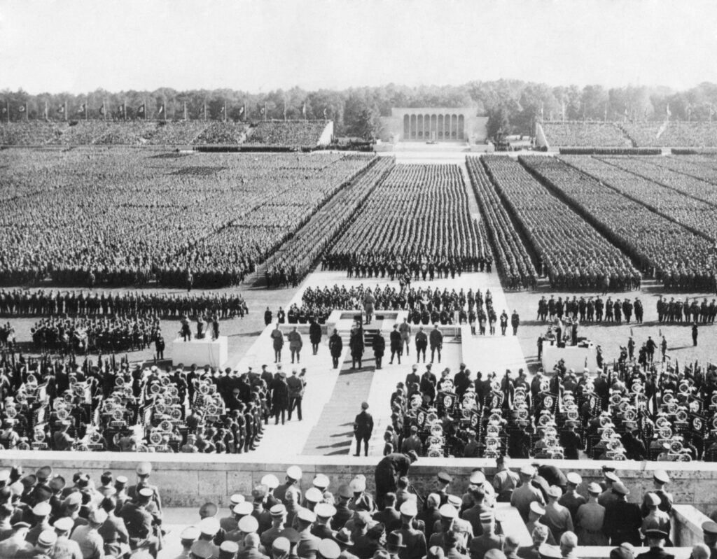 An image of a crowd of Nazi soldiers standing in columns behind Hitler at the 1938 Hitler rally in Nuremberg.